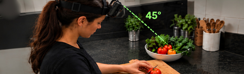 Pessoa com o celular preso na cabeça, inclinado em 45°, cortando um tomate